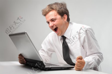坐在电脑前兴奋的外国男士图片