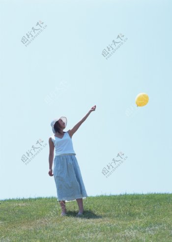 草地上玩气球的美女图片