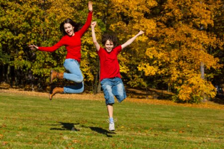 秋天草地风景与跳跃的青少年图片