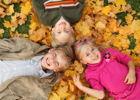 开心躺在枫叶上的儿童图片