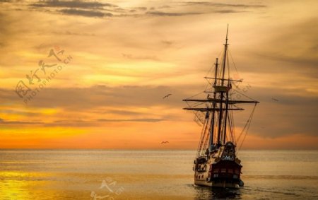 夕阳下海上行驶的帆船