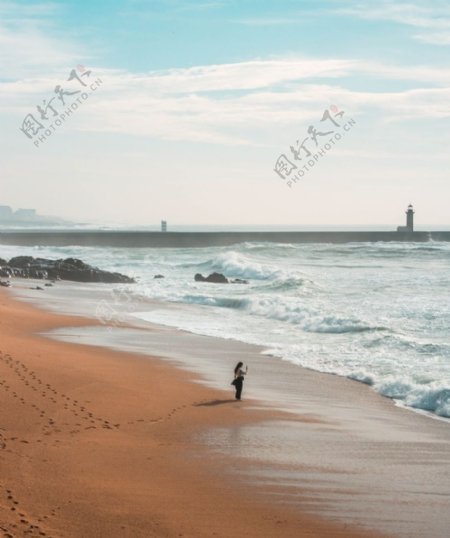 一个人行走在海边沙滩上